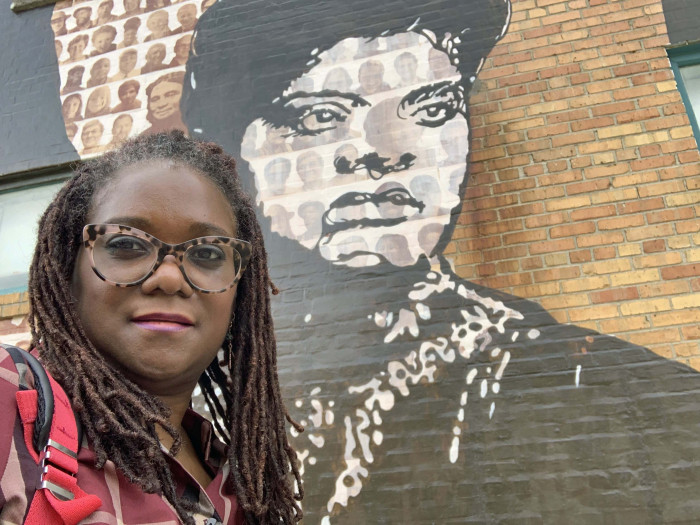 Deborah Douglas in front of mural of Ida B. Jones