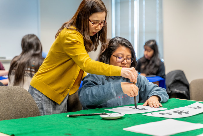 Hiroko Chiba helps a student learning Japanese calligraphy.