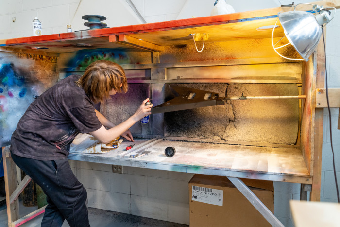 A student paints the body of his electric guitar.