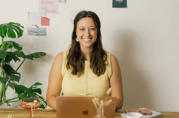 female in yellow shirt sitting in front of laptop