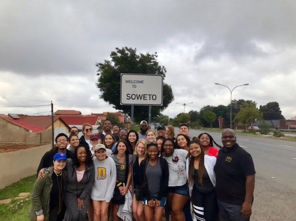 Students in front of Soweto, South Aftrica road sign