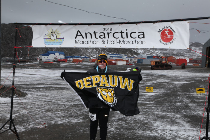 Luis Davila displays the DePauw flag in Antarctica