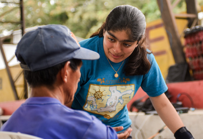 Rubina Cheema ’23 assists an Ecuadorian man 