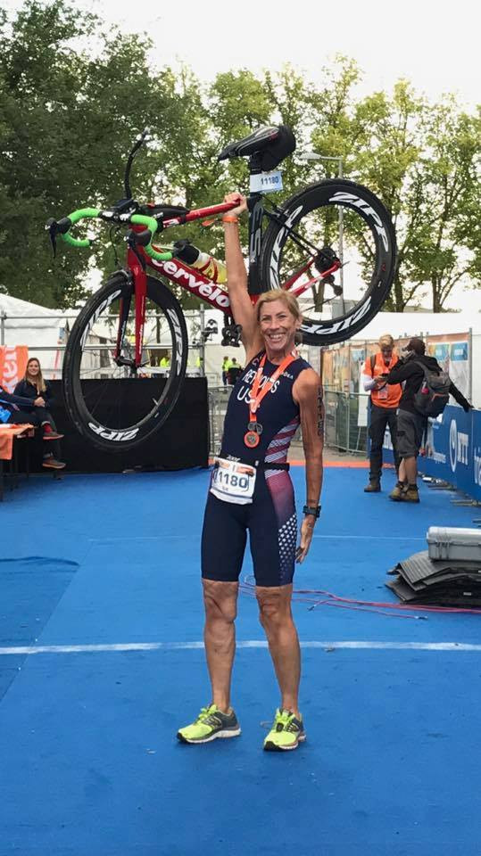 Sue Reynolds holds her bicycle aloft 