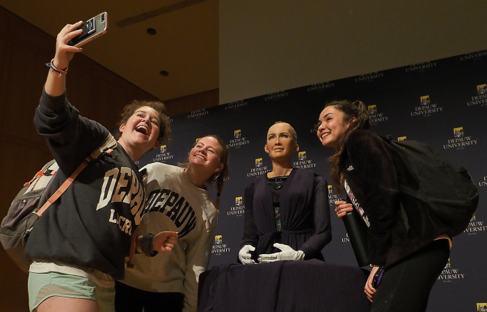 Students taking selfies with Sophia