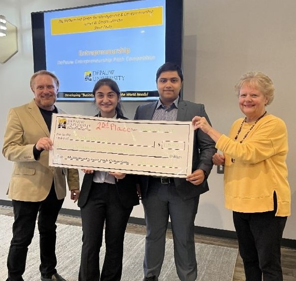 Students Anna Baig and Yousaf Khan smiling with a giant check