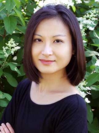 Smiling woman in front of a leafy plant