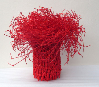 Red Washi paper that has been tied at the top and turned into a cylinder on the bottom 