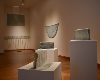 Laura Mongiovi installation image of six light blue objects on pedestals and the wall