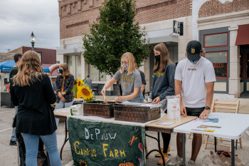 Students working a table at First Friday