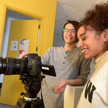 two people smiling looking at video camera