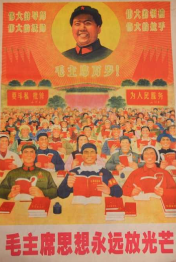 A lot of people holding up red books while seated at desks and smiling. An image of President Mao is in a circle on the top center of the image