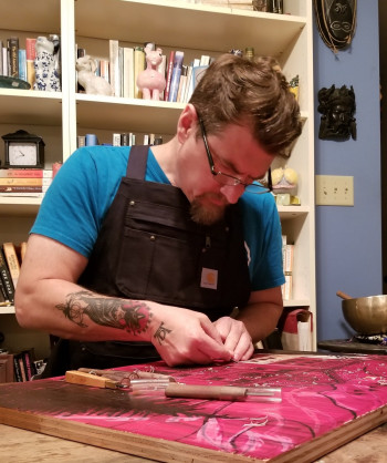 man in art studio woodblock carving