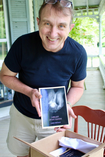 Joe Heithaus with his book of poetry