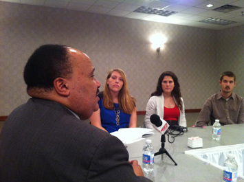 Martin Luther King III talking with students at a table
