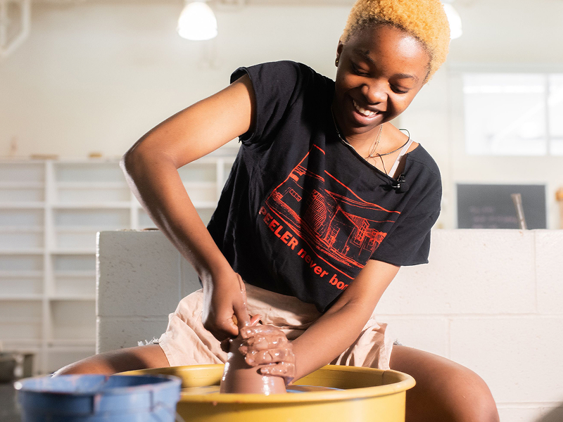 female using clay spinning wheel