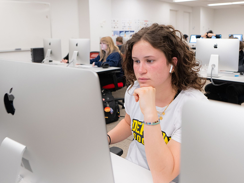female student looking at computer screen