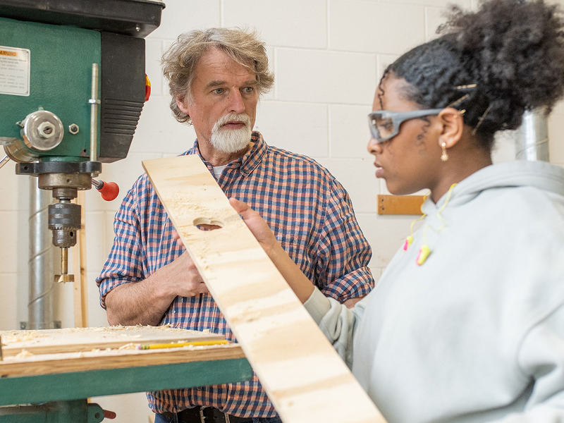 instructor with female student at bandsaw