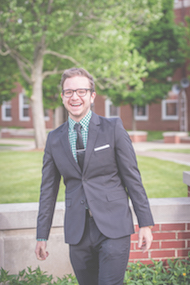 Ryan Pranger in a suit in the Holton Quadrangle