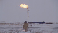 man walking in snow with fire in background