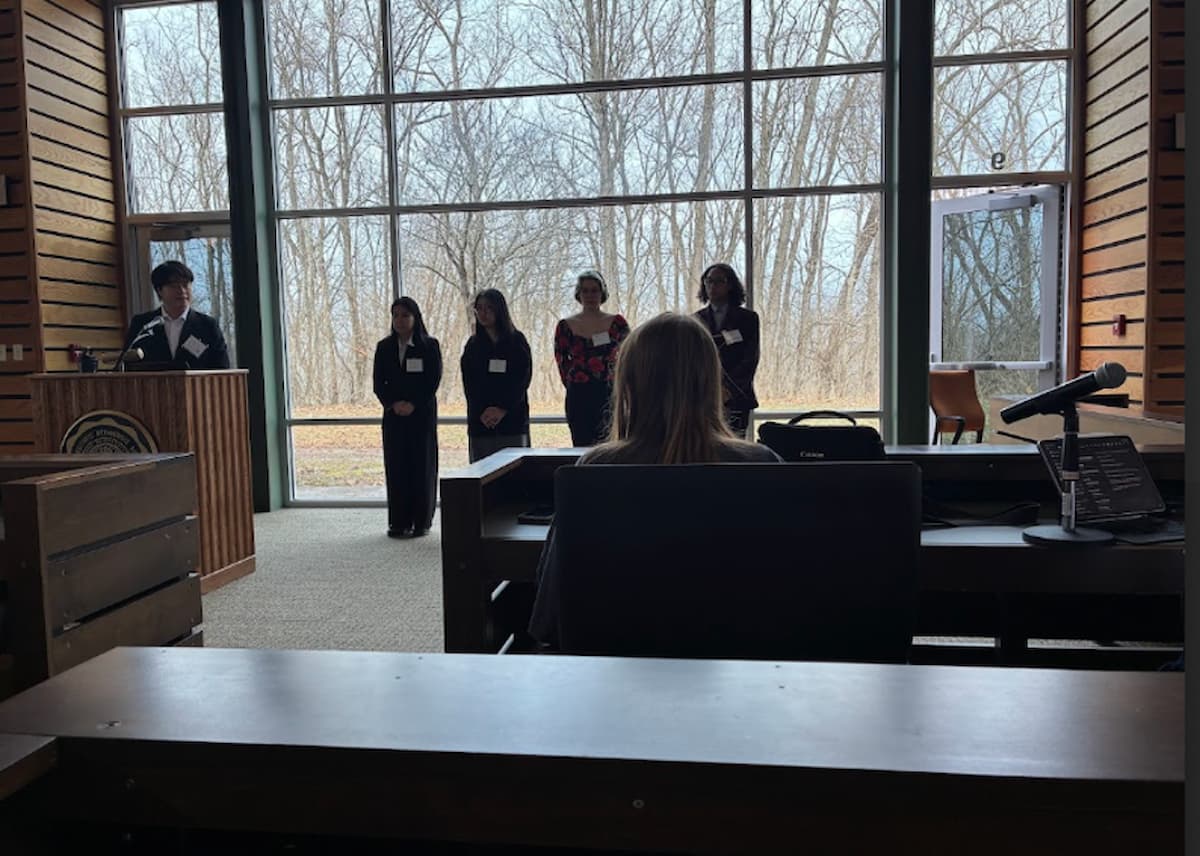 Student teams give a press conference where they are peppered with questions by reporters