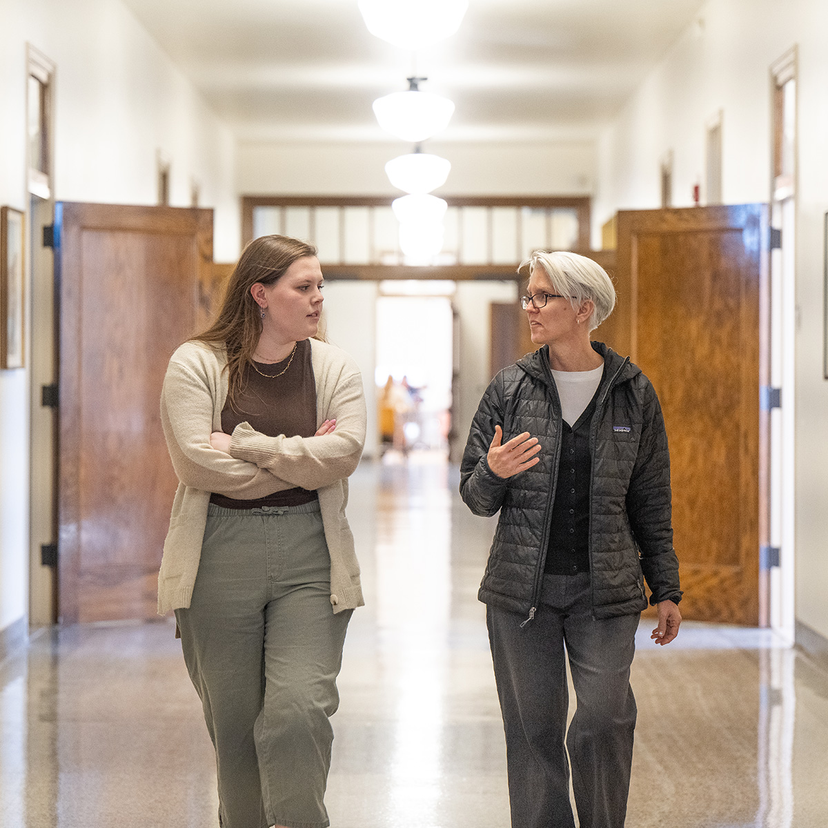 Student and Faculty Member walking side-by-side in the corridor of Asbury Hall