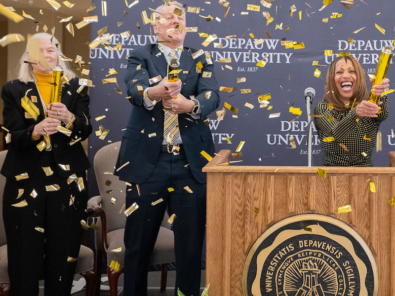 people celebrating at podium with confetti