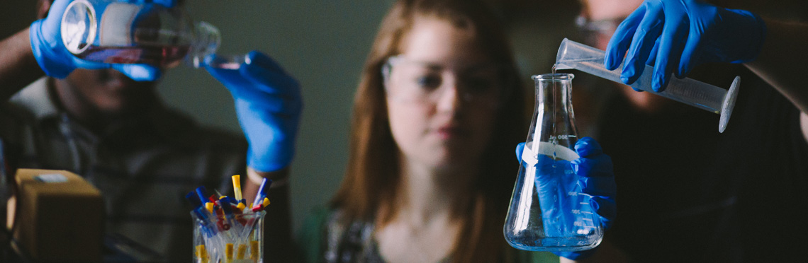 male and female in a lab with beakers