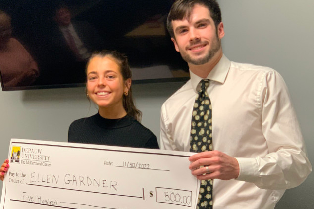 male and female holding winning check at competition