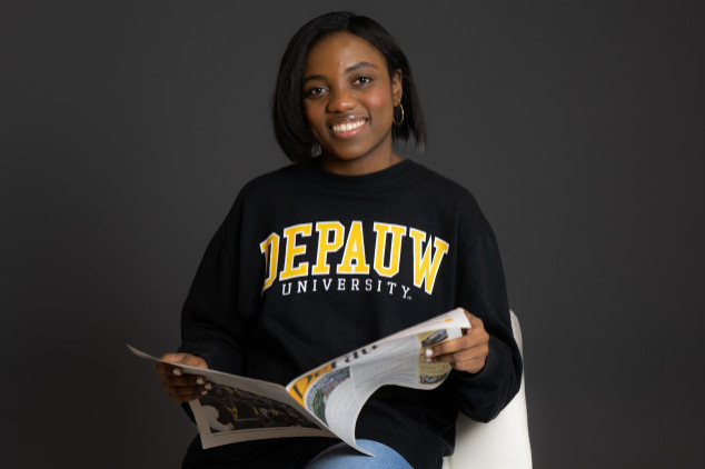 female reading magazine on stool