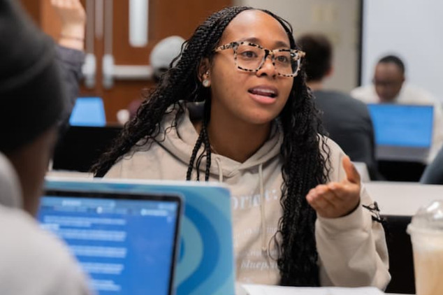 A student leading a group discussion in a classroom