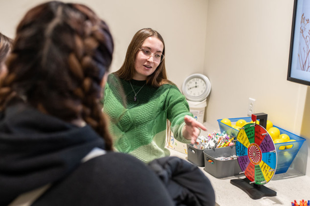 female in glasses spinning wheel on counter with prizes