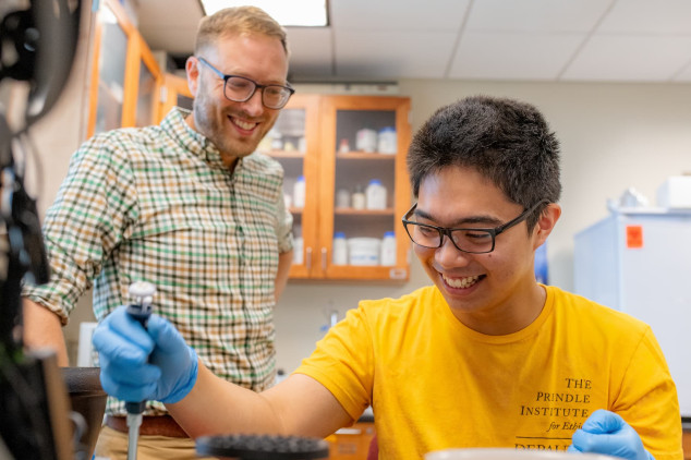 Teacher and student performing science research in lab.