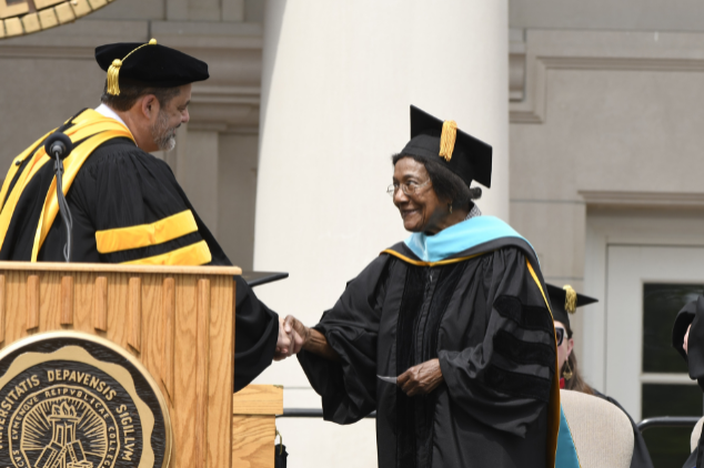 Dorothy Brown shaking hands on stage during commencement