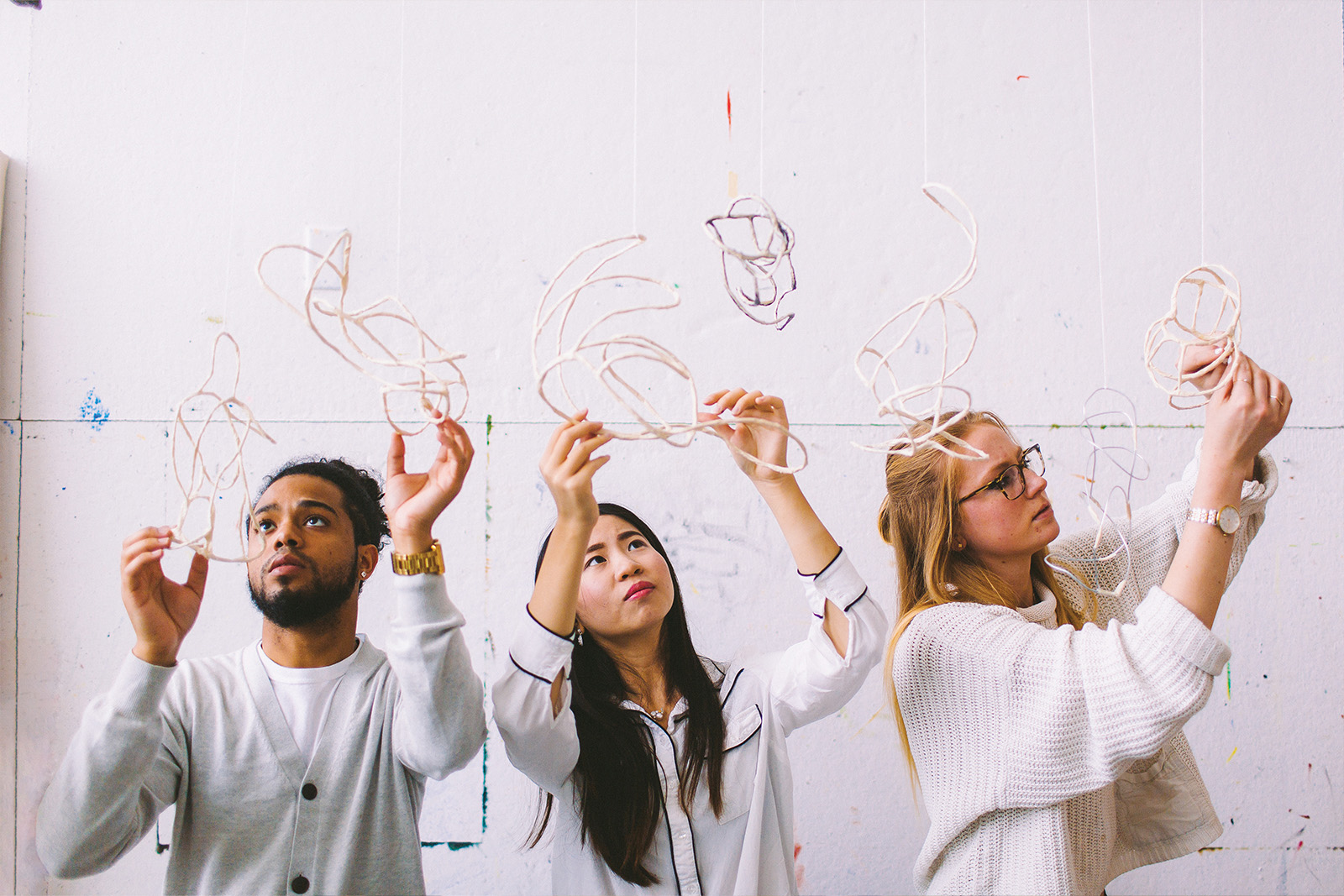 Three students touching kinetic art