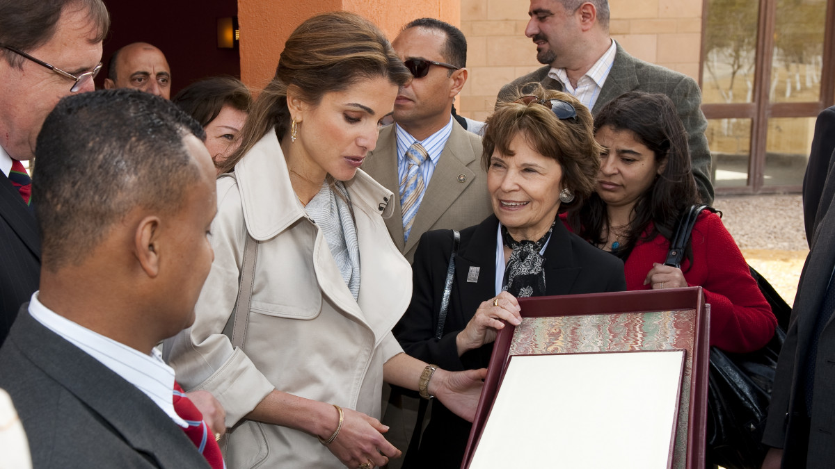 Barbara Lethem Ibrahim '71 watches as Queen Rania of Jordan looks at a photo album.