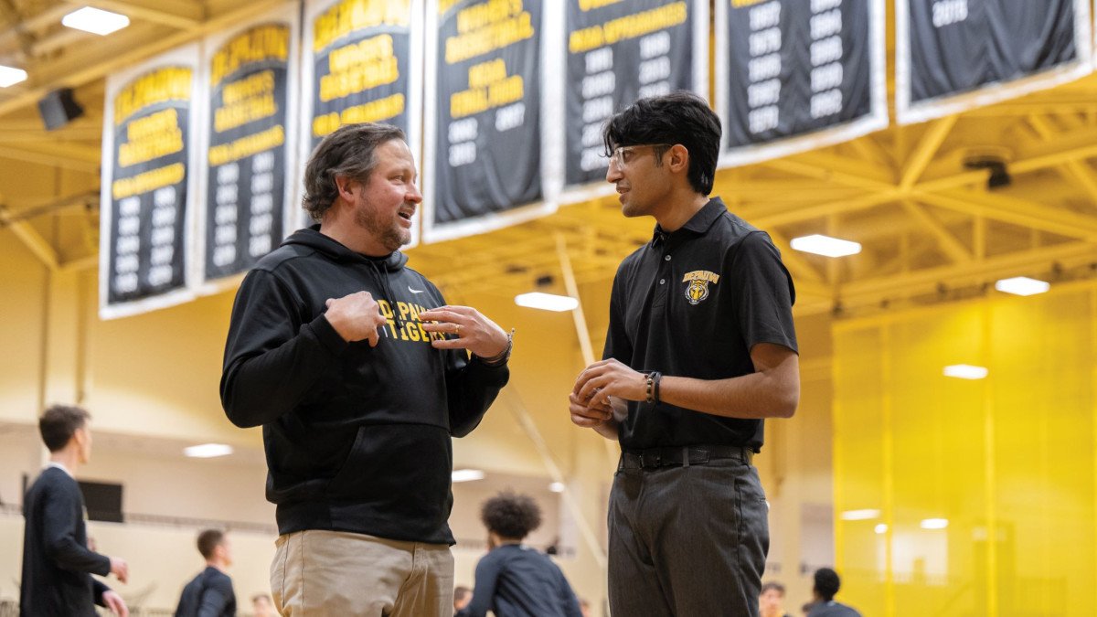 Student and professor talking at basketball game