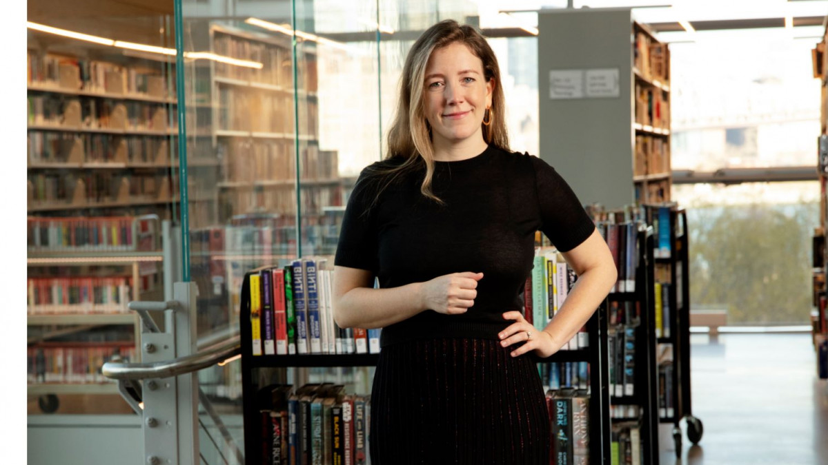 Ad director Emily Jarrett '09 stands in front of windows and bookshelves