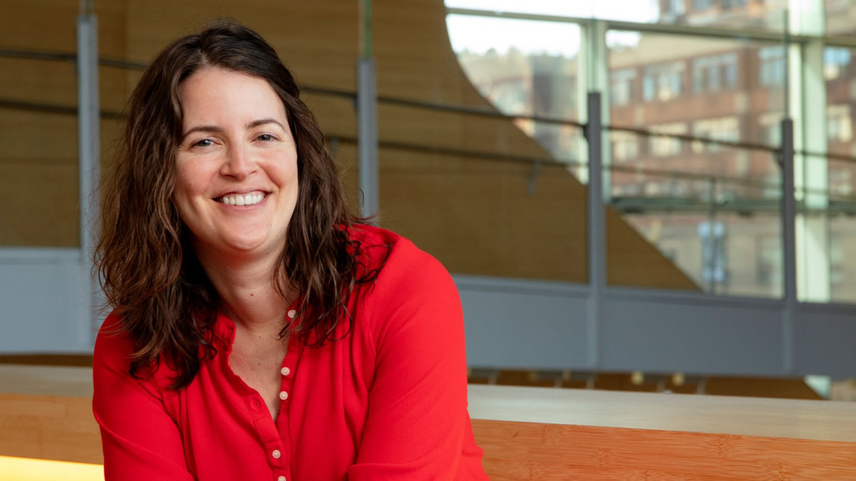 Hallie Patterson '07 sits on a table in front of an oval window