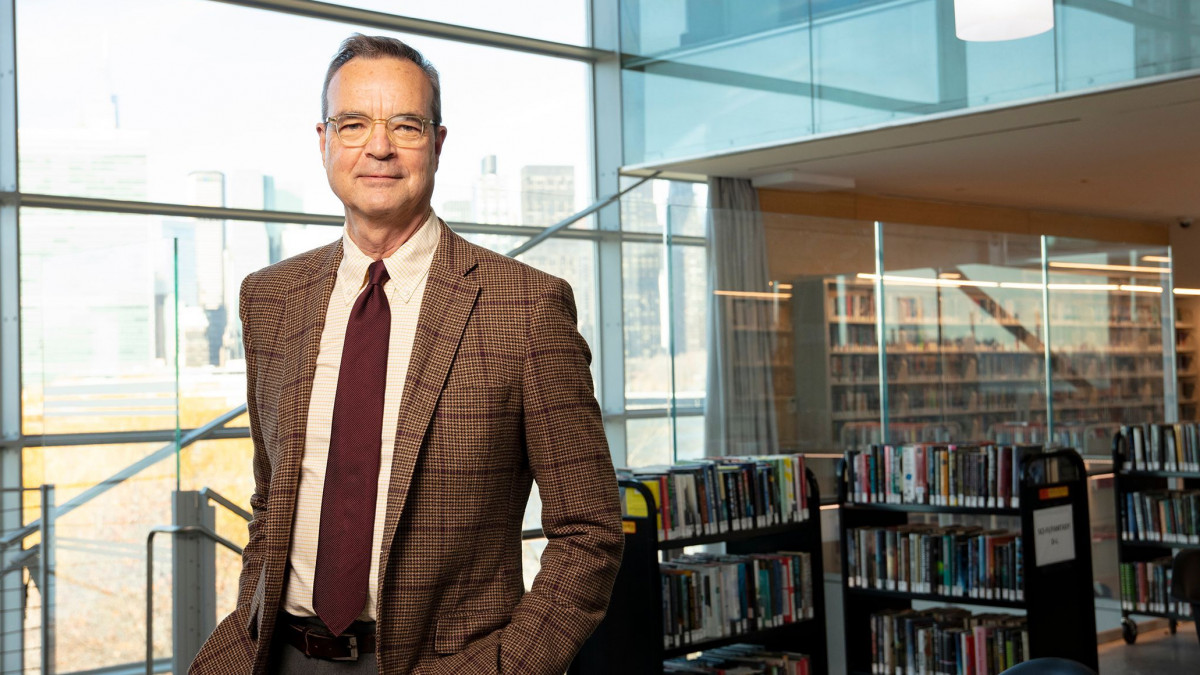 James Stewart '73 in front of books and large windows