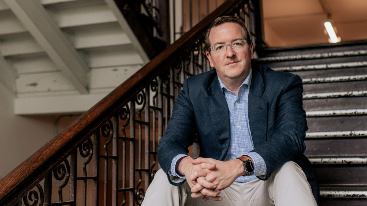 Nathan Hand '03 sits on a staircase