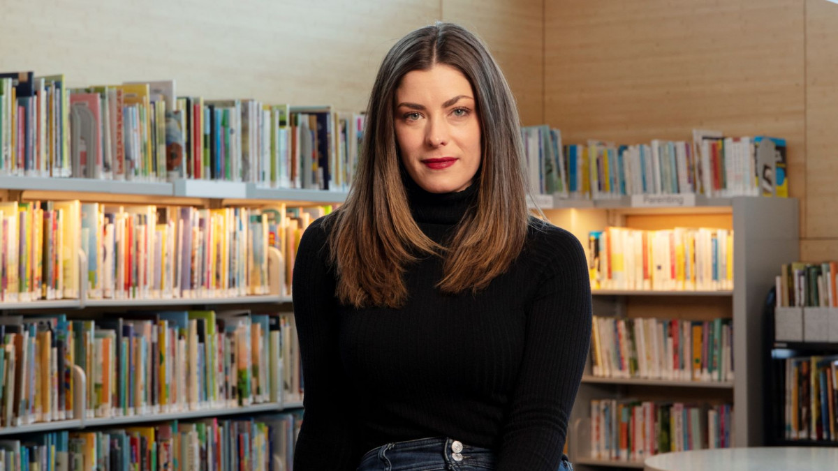 Kate Kendrick '14 sits in front  of book shelf 