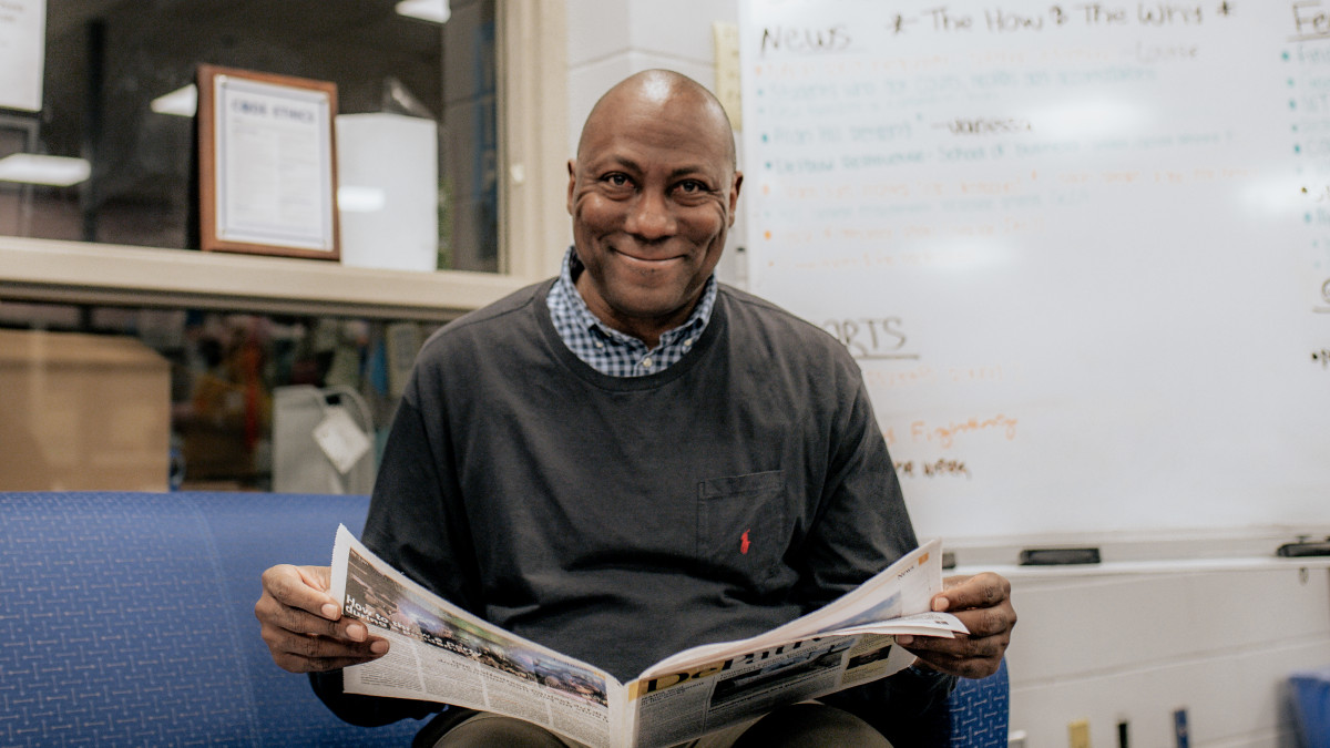 Samuel Autman looks up while reading student newspaper