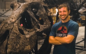Alex Ruger next to a T-Rex skeleton