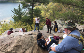Structure students discussing their cross-sectional interpretations of the Baraboo Syncline on a bluff overlooking Devil's Lake.