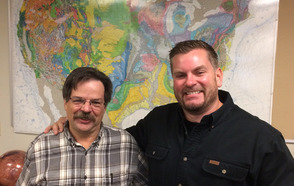 Nic Brissette and Jim Mills in front of a Geosciences map