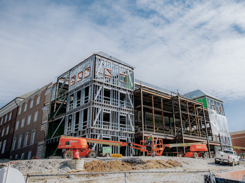 Construction site exterior showing steel framing and orange lifts