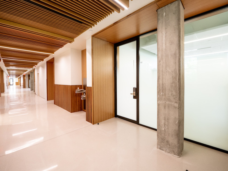 Modern university hallway with wood paneling and concrete column