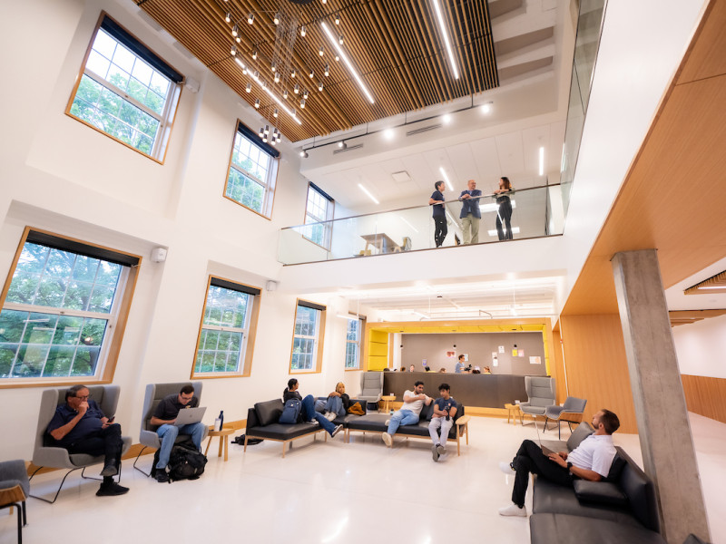 Two-story student lounge with high ceilings and wood accents