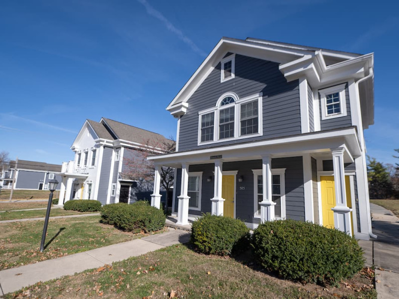 Blue and gray duplexes with white pillars and yellow doors
